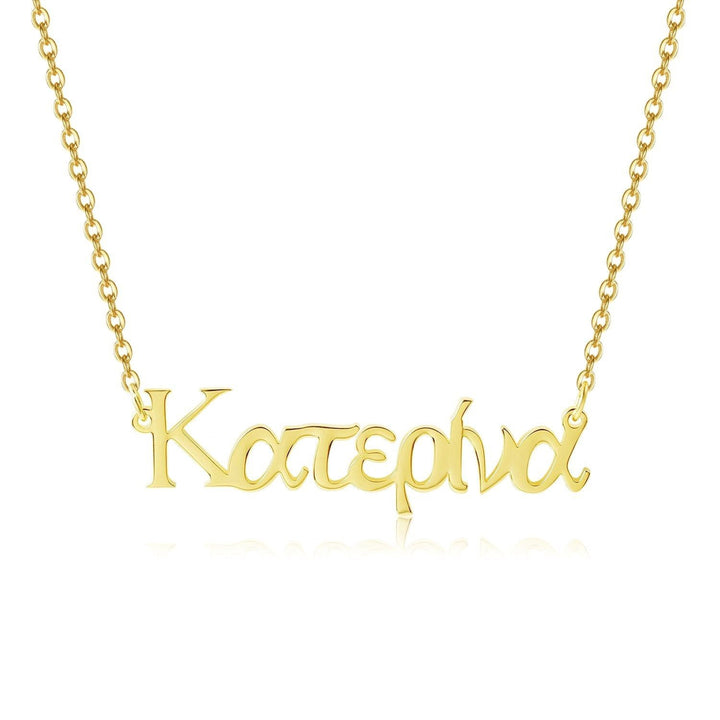 A gold-colored necklace with the word "Katerina" engraved on it.
