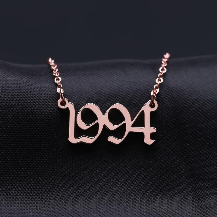 A necklace with the number "1994" engraved on it, displayed against a dark background.