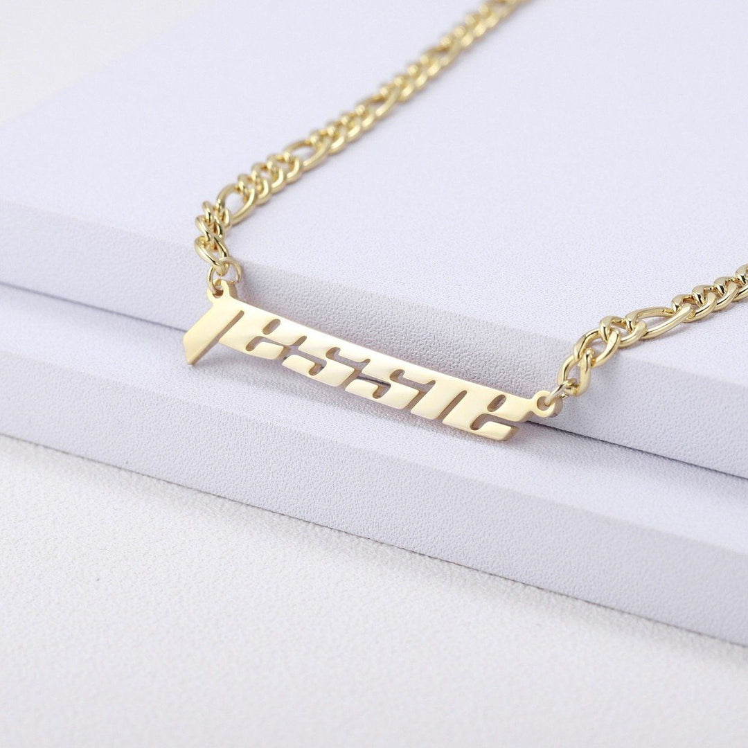 A gold-colored necklace with a pendant that says "JESSIE" in a cursive font.