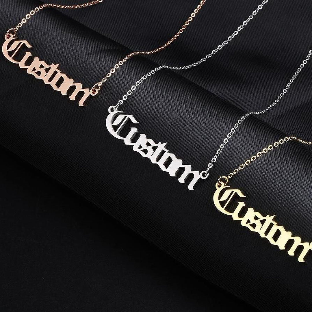 three necklaces with the word "Custom" engraved on them in different colors: gold, silver, and pink.