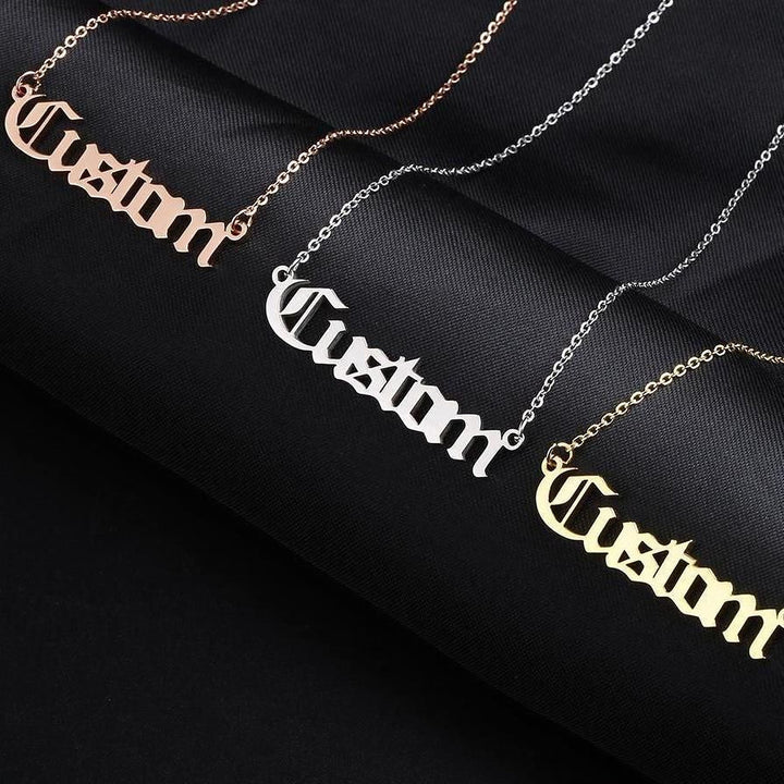 three necklaces with the word "Custom" engraved on them in different colors: gold, silver, and pink.