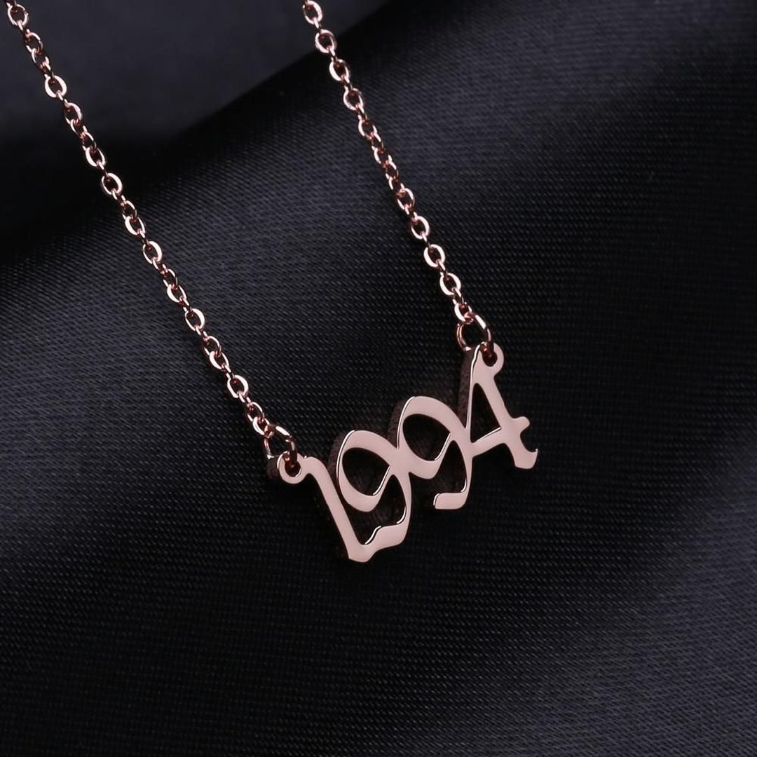 A necklace with the year "1994" engraved on it, displayed against a dark background.