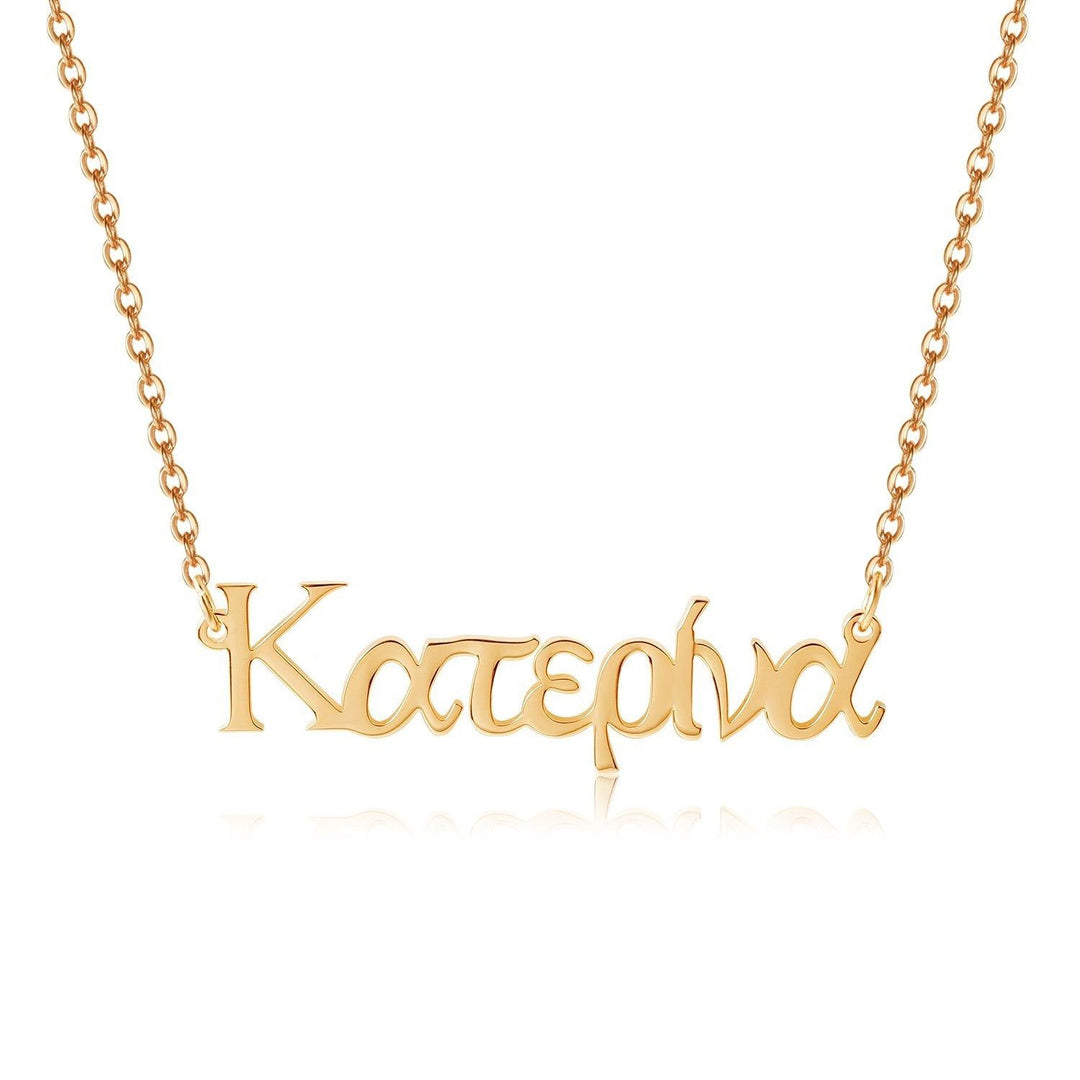 A gold-colored necklace with the word "Katerina" engraved on it.