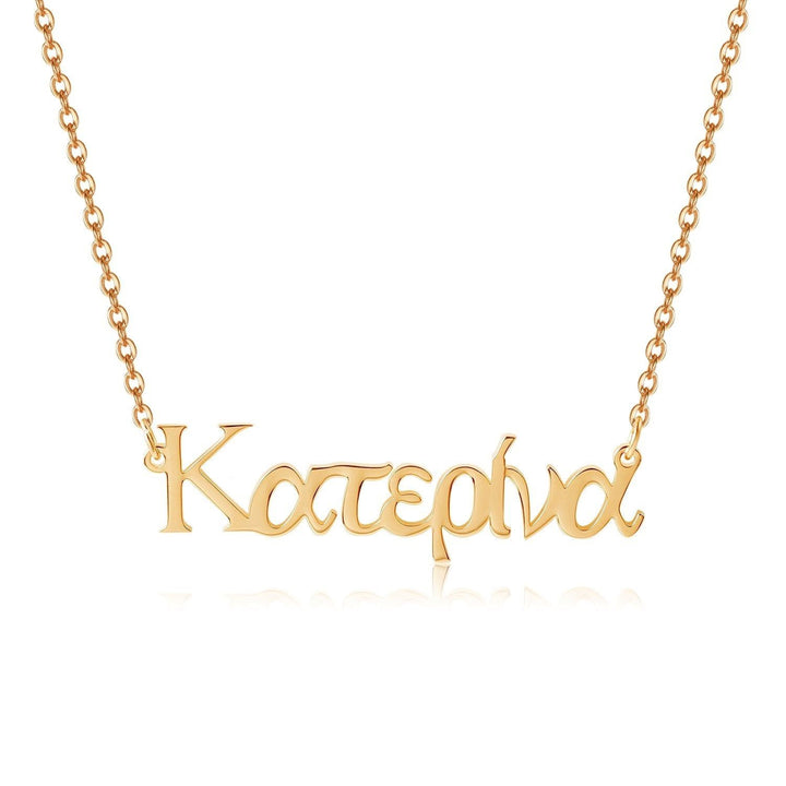 A gold-colored necklace with the word "Katerina" engraved on it.