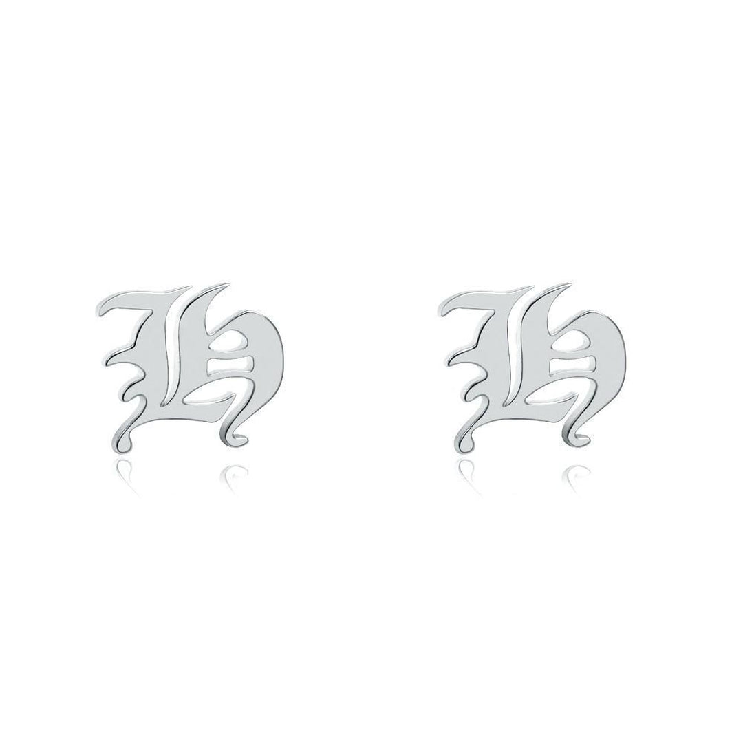 two silver earrings with the letter &