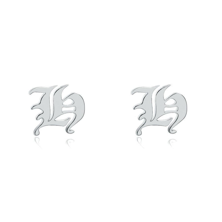 two silver earrings with the letter &